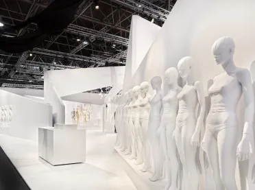 Trade fair booth at Euroshop - Genesis Euroshop Düsseldorf - stand view from right - mannequins in a row - white wall panels