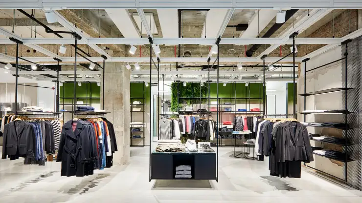 young womens fashion store - complete redesign - Kaiser Freiburg - interior architecture - wide angle store overview - green wall - steel racks