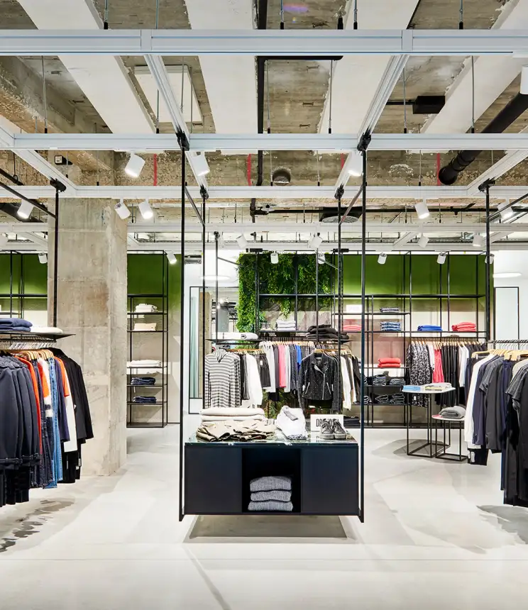 young womens fashion store - complete redesign - Kaiser Freiburg - interior architecture - wide angle store overview - green wall - steel racks