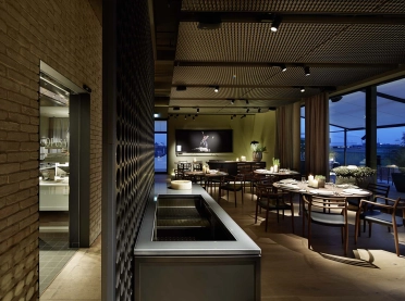 gourmet restaurant - new construction - Restaurant Opus V Mannheim - engelhorn - split view kitchen and dining area - evening twilight