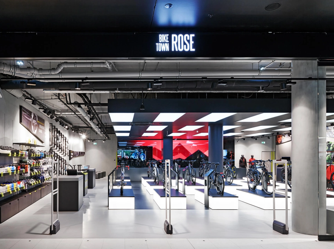 bike sports specialist store - new conception - Rose Biketown Munich - view from entrance area towards store - big led screen in back - store overview