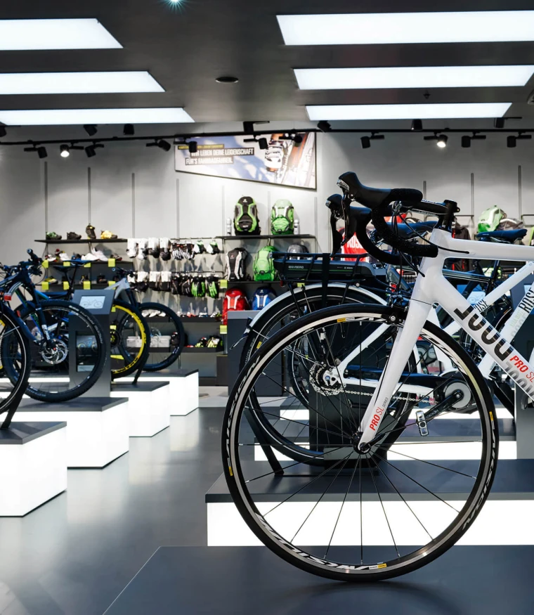 bike sports specialist store - new conception - Rose Biketown Munich - view through store - illuminated bike display podium detail - display walls in back