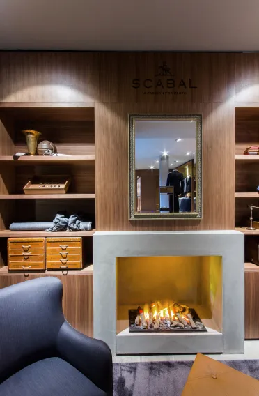 Flagship Store - luxury brand - clothing and suits - Scabal Brussels - salon - sunken fireplace - victorian mirror - wooden display shelf - cozy blue armchair