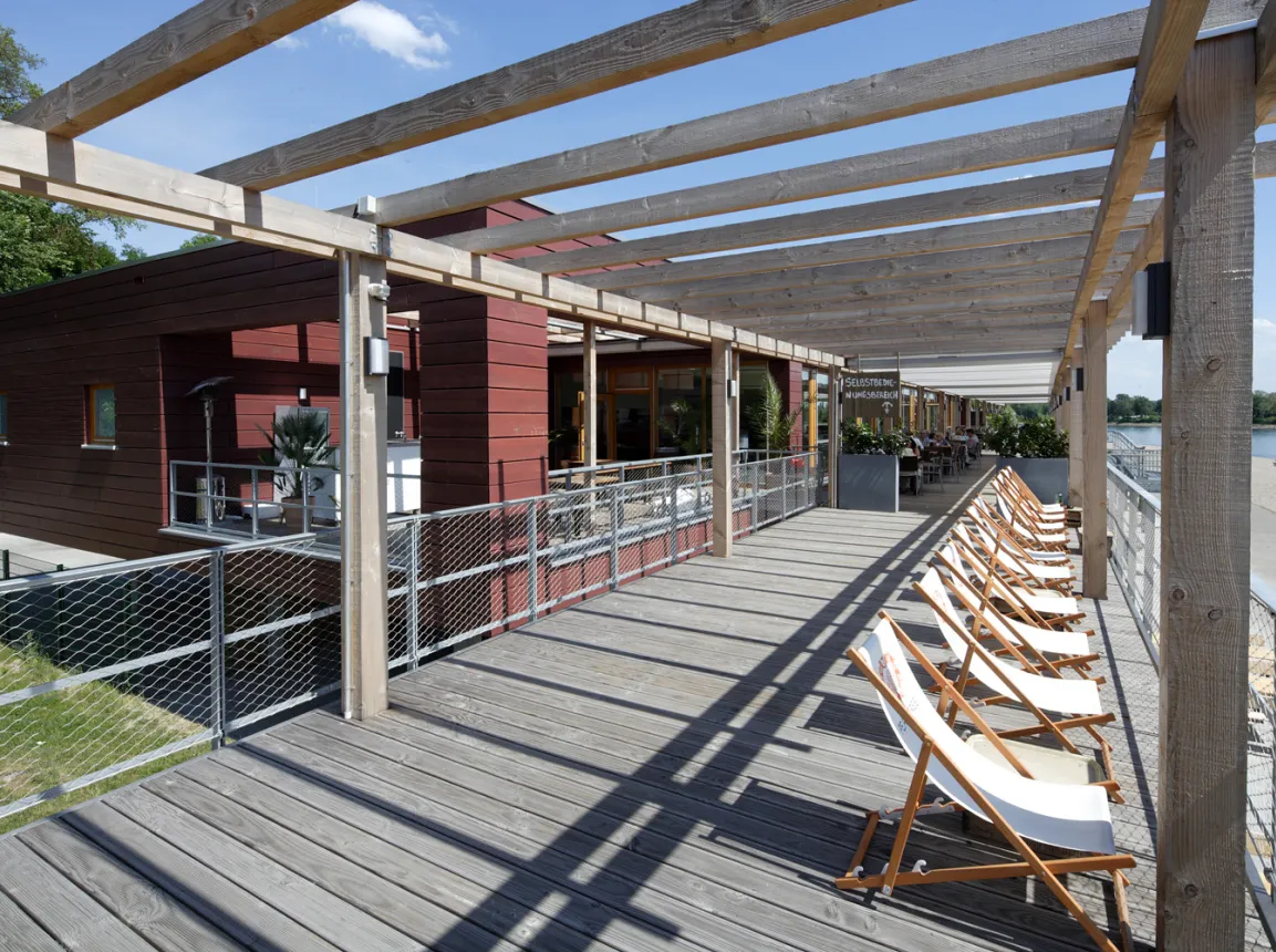 gastronomy building - construction - green building standards - competition - Strandbad Mannheim - top level outside terrace area - deckchairs - wooden terrace floor and shading