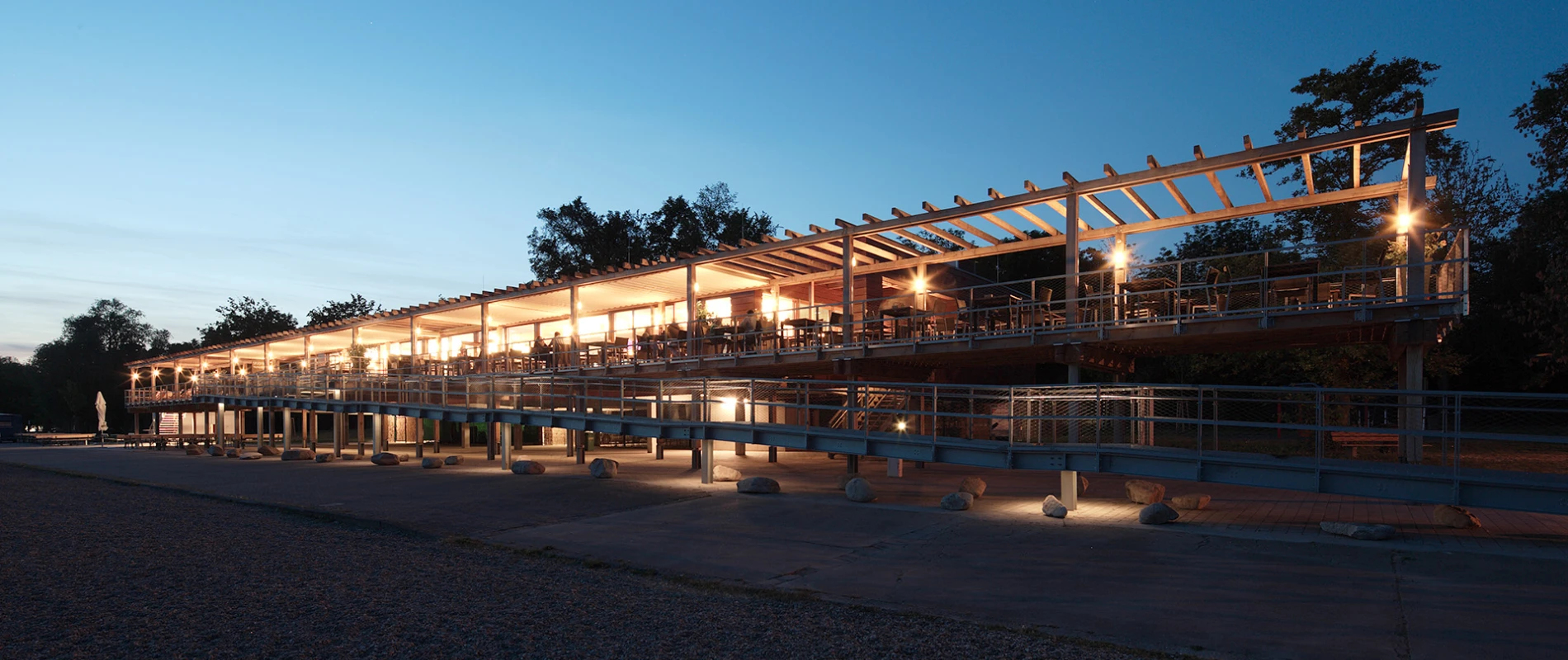 gastronomy building - construction - green building standards - competition - Strandbad Mannheim - outside building overview - wood-frame construction - illuminated by night