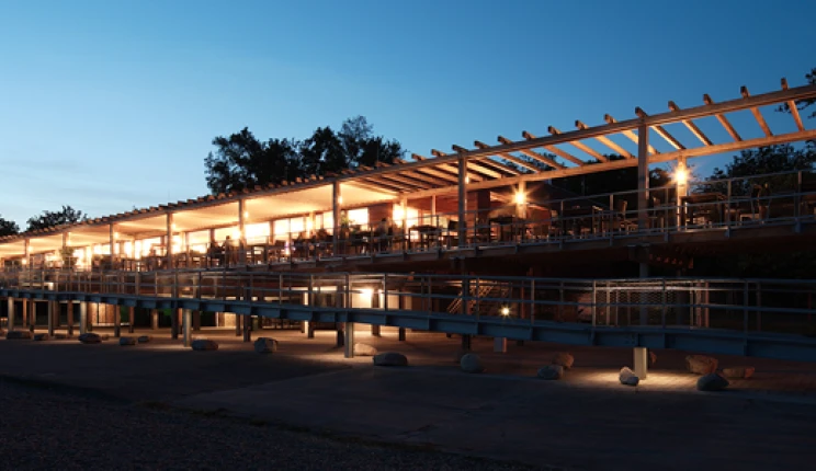 gastronomy building - construction - green building standards - competition - Strandbad Mannheim - outside building overview - wood-frame construction - illuminated by night